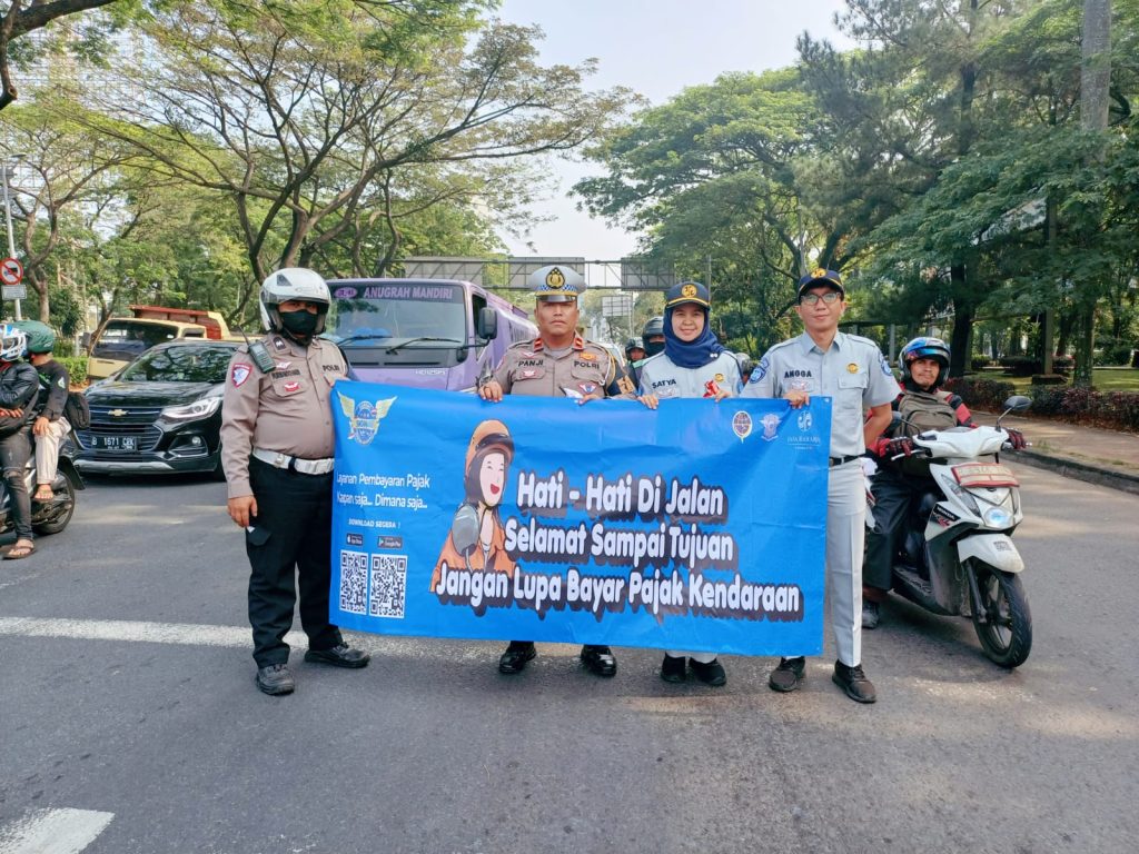 Kanit Kamsel Ipda Panji Setiawan dan Satya Wardhani dari Jasa Raharja Tangerang turun ke jalan menyampaikan pesan keselamatan kepada warga masyarakat agar selalu berhati-hati dalam berkendara dan membagikan bendera merah putih